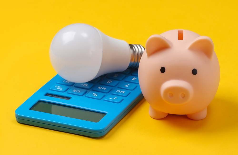 Piggy,Bank,And,Led,Light,Bulb,,Calculator,On,Yellow,Background.